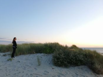 Side view of man standing on land against clear sky