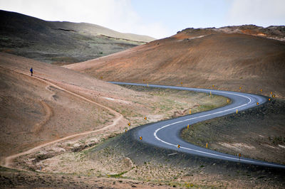 Road passing through mountain against sky