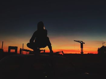 Silhouette man sitting on bicycle against sky during sunset