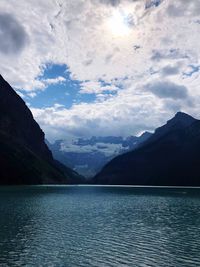 Scenic view of lake by mountains against sky