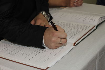 Bridegroom writing on book