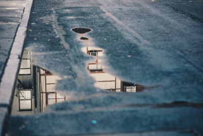 Tilt image of car on street against sky during winter