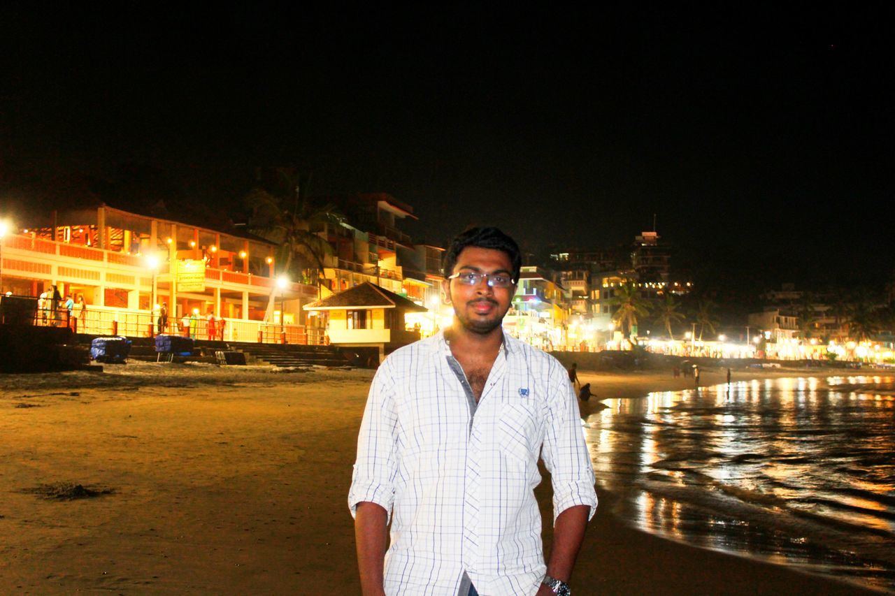 lifestyles, young adult, person, casual clothing, portrait, looking at camera, leisure activity, night, front view, illuminated, young men, standing, building exterior, water, sunglasses, smiling, happiness