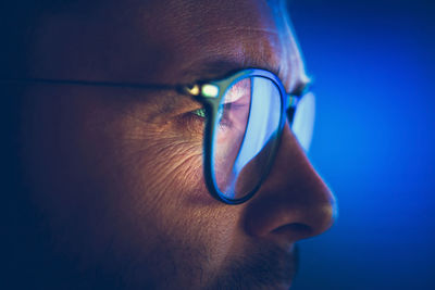 Focused on computer display caucasian entrepreneur in glasses close up photo.