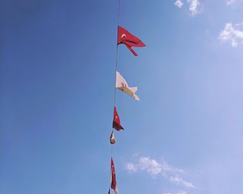 Low angle view of flags hanging against sky