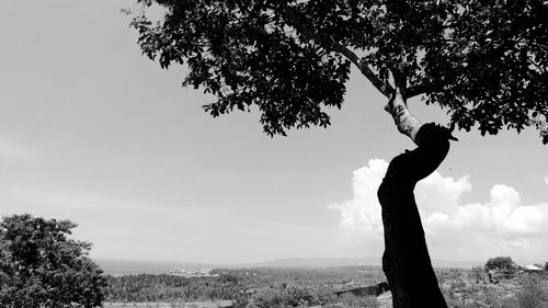 Low angle view of silhouette person standing on landscape against sky