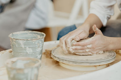 Modeling on a potter's wheel. hands are molded from clay. working atmosphere in the workshop. 