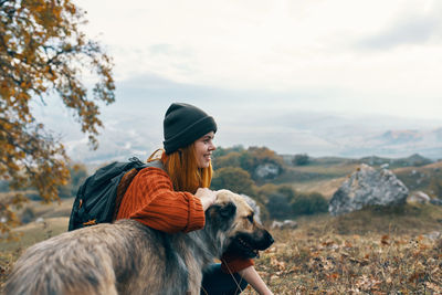 Rear view of man with dog in the background