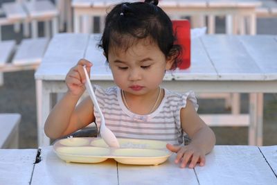 Cute girl sitting on table