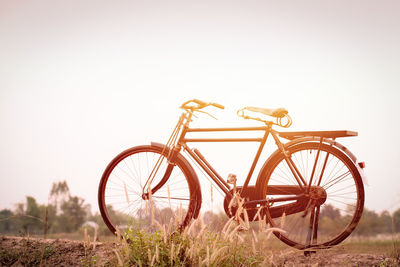 Bicycle wheel on field against clear sky