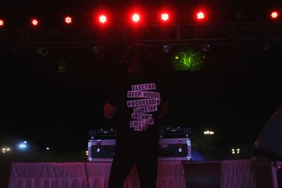 Rear view of dj playing music in nightclub