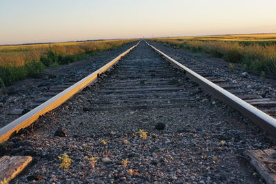 Railroad track amidst field against sky