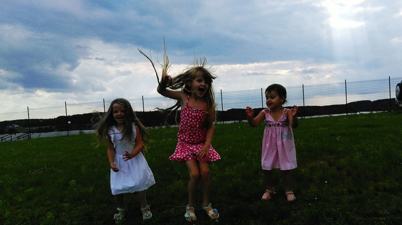 lifestyles, leisure activity, childhood, girls, full length, grass, boys, casual clothing, enjoyment, sky, fun, playing, happiness, playful, family, field, friendship, cloud - sky, grassy, day, outdoors