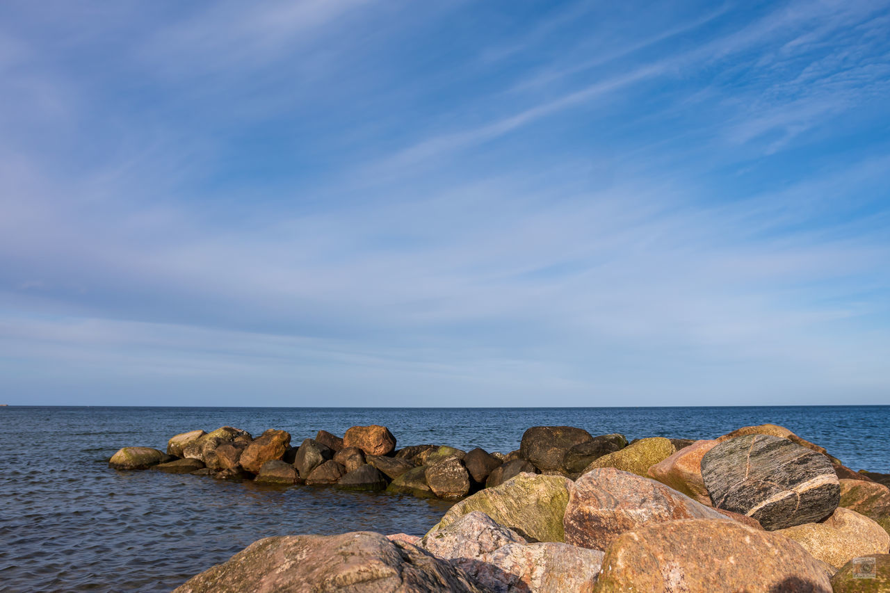 ROCKS ON BEACH AGAINST SKY