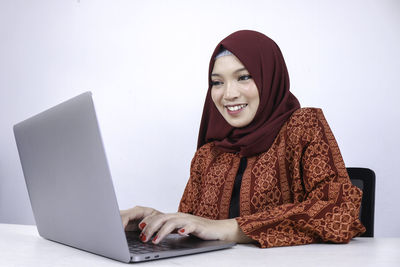 Portrait of a smiling young woman using phone