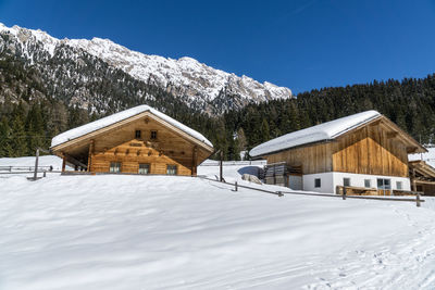 Houses on snow covered landscape against sky