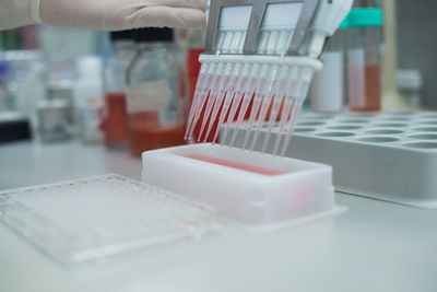 Cropped hand testing chemicals in laboratory