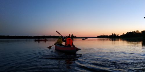 Boat in lake against sky during sunset