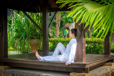 Side view of a woman sitting on plants