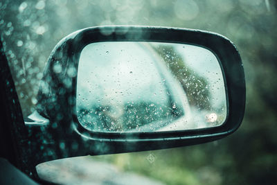 Water drops on side-view mirror of car