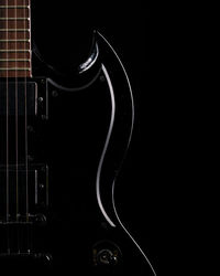 Close-up of guitar against black background