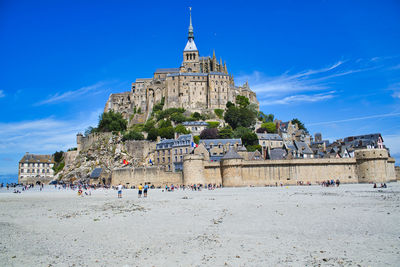 Group of people on beach against buildings