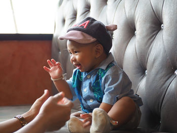 Cute boy looking down while sitting on floor