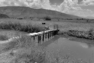Wooden posts on field against sky