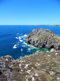 Scenic view of sea seen from cliff against sky