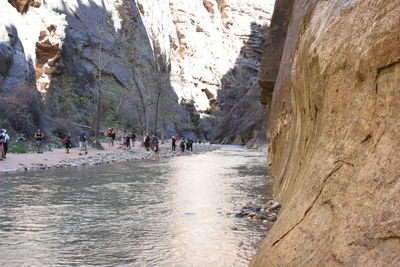 People on river amidst rock formation