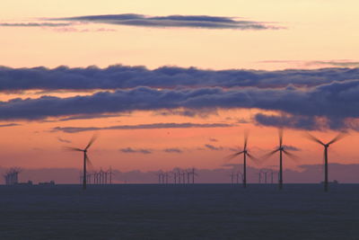 Wind turbines in sea during sunset