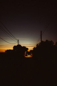 Silhouette electricity pylon against sky during sunset