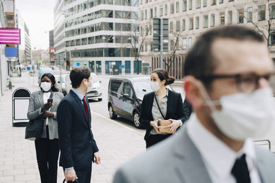 Business people talking on footpath in city during pandemic