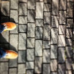 Low section of man standing on tiled floor