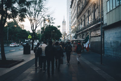 Group of people walking on sidewalk in city