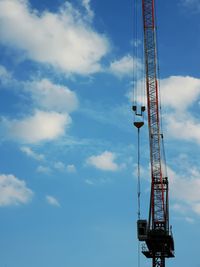 Low angle view of crane against blue sky