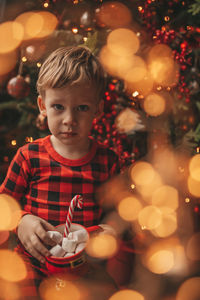 Portrait of cute girl decorating christmas tree at night