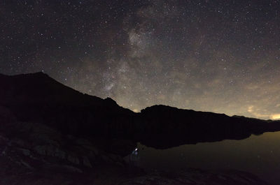 Scenic view of silhouette mountain against sky at night