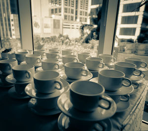 Close-up of cup and saucer stacks on table at restaurant