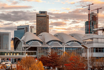 Buildings in city against cloudy sky