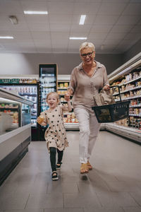 Happy senior woman enjoying with granddaughter while shopping at store