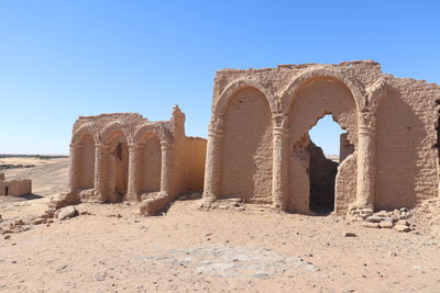 Ruins of historical building against clear blue sky