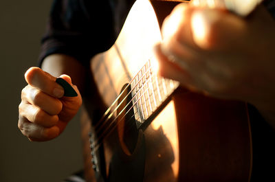 Midsection of man playing guitar