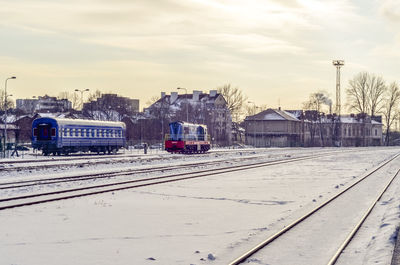 Train in railroad tracks against sky during winter