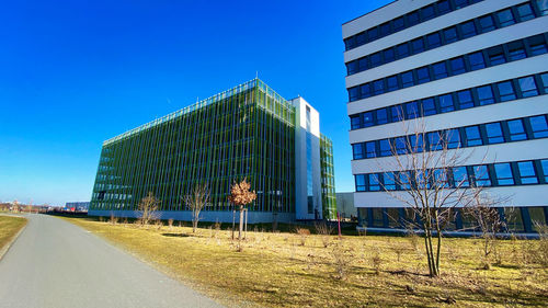 Modern buildings against clear blue sky in city