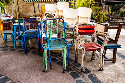 Pile of old colored iron chairs on the square of a southern european village