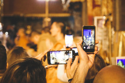 Reflection of people photographing on smart phone