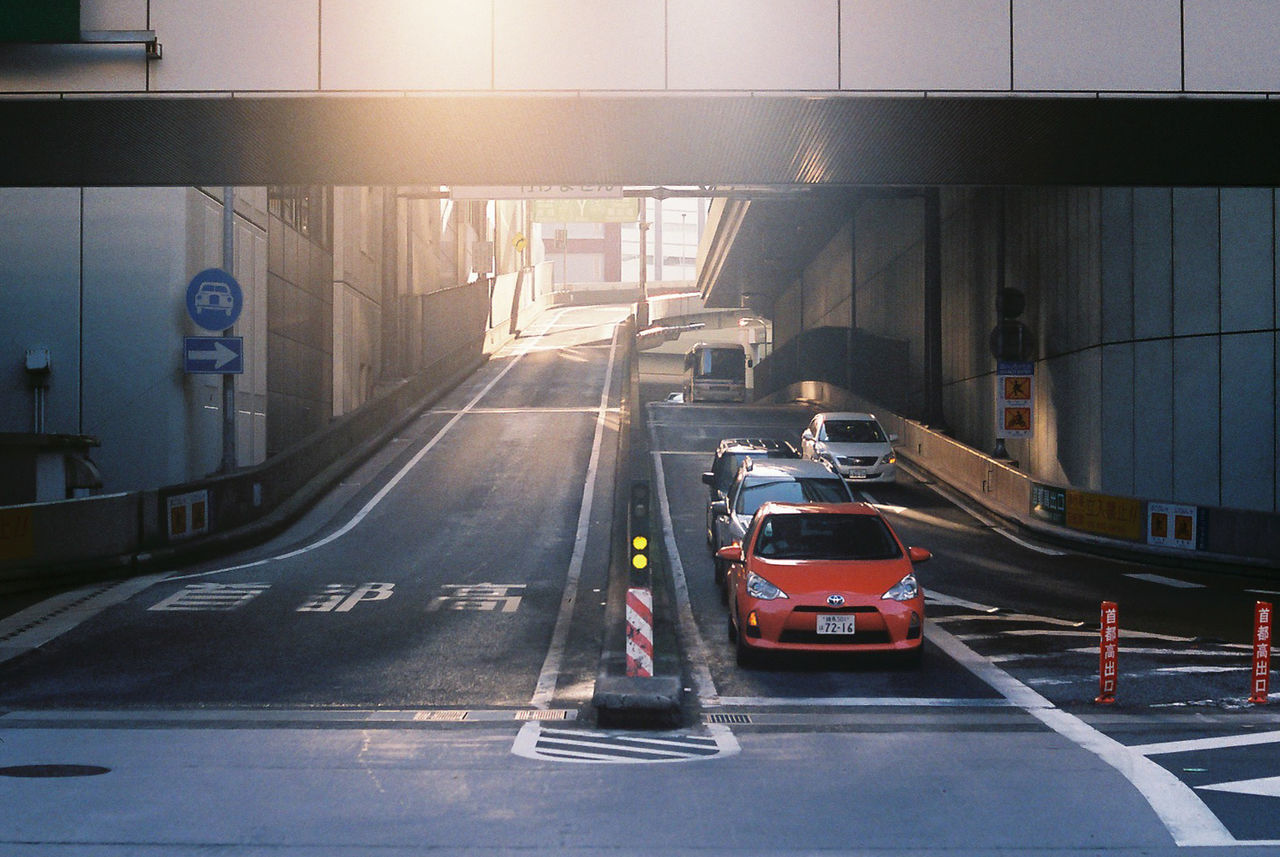 VEHICLES ON ROAD ALONG BUILDINGS