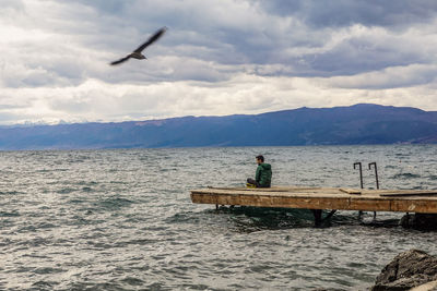 Birds flying over sea against sky