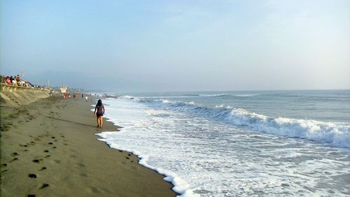 Men in sea against clear sky